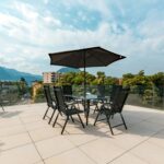 Spacious patio with seating and umbrella overlooking mountains and cityscape.