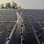Dew droplets on solar panel in São João do Piauí, Portugal, reflecting morning light.